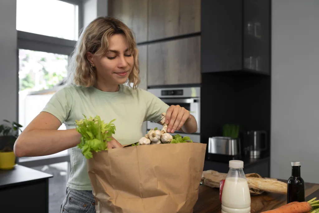 Frau packt Knoblauch aus Einkaufstüte