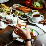 Bild von einer Hand die sich Frischkäse auf ein Toast schmiert